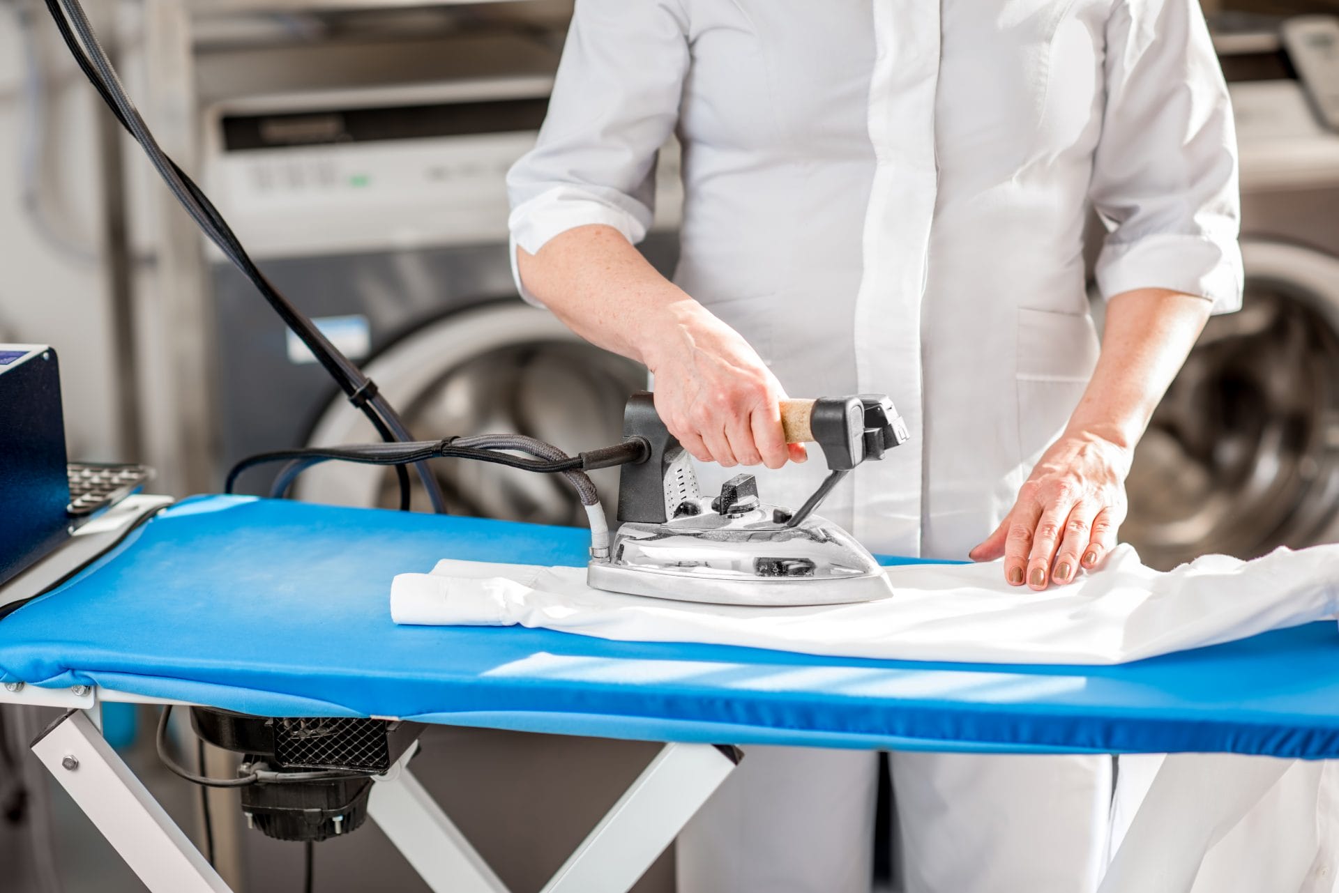 A woman ironing a shirt on an ironing board.